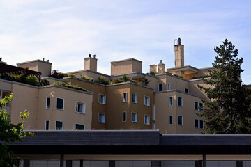 Obraz premium Block of flats with trees growing on the roof terraces captured in low angle view. 