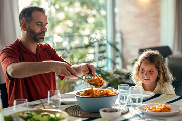 Beautiful kind family talking while eating together in the kitchen at home