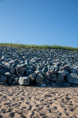 Rocks along beach with blue sky