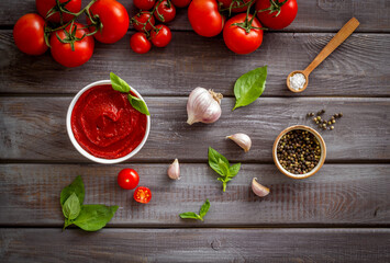 Tomato sauce passata in bowl with fresh tomatoes and basil