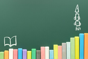multicolored chalks on green chalkboard background, copy space, back to school concept and growth...