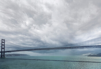 San Francisco, CA, USA - July 13, 2023: Heavy storm clouds approaching over Golden Gate Bridge with...