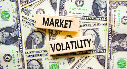 Market volatility symbol. Concept words Market volatility on beautiful wooden blocks. Dollar bills. Beautiful background from dollar bills. Business market volatility concept. Copy space.orange