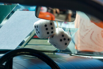 a pair of fuzzy dice hanging from the car mirror