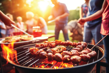 Group of friends and family having party outdoors. Focus on barbecue grill with food.