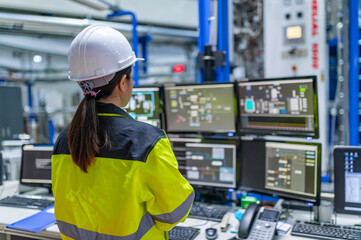 Inside the large Industry Factory Female Computer Engineer Works on Personal Computer She coding...