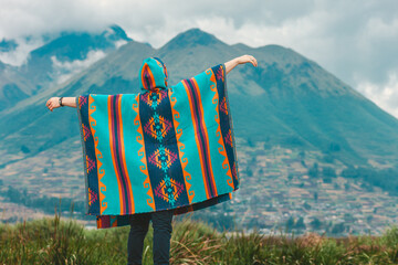 Model wearing a poncho handmade with sheep cloth by the indigenous Kichwa artisan communities of the area, posing at the San Pablo lake in Otavalo, Ecuador.