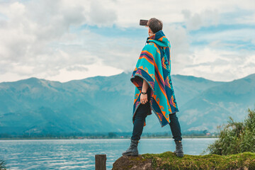 Model wearing a poncho handmade with sheep cloth by the indigenous Kichwa artisan communities of the area, posing at the San Pablo lake in Otavalo, Ecuador.