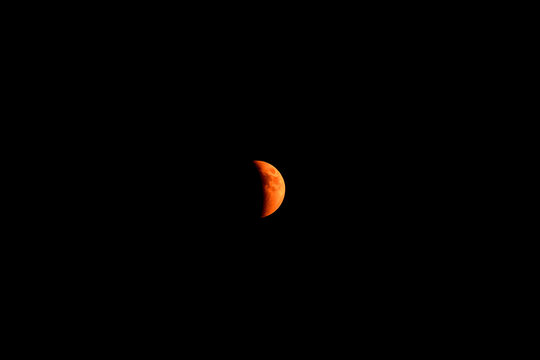 Crescent blood moon total eclipse over Flagstaff Arizona with black sky and stars