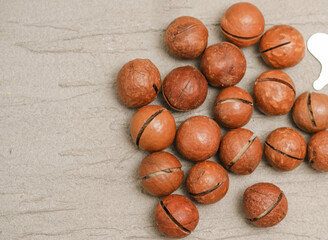 Close-up of macadamia nuts on a gray tree background, the concept of superfoods and healthy nutrition, a picture from above, a copy space for business