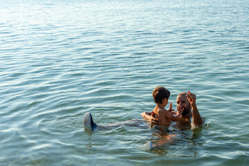 Portrait of father and son laughing on summer vacation bathing on the beach