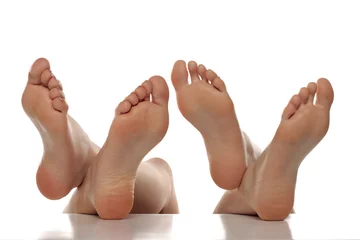 Fototapeten Two pairs od a beautiful well-groomed women's sole feet close-up on a white isolated background, The concept of foot skin care © vladimirfloyd