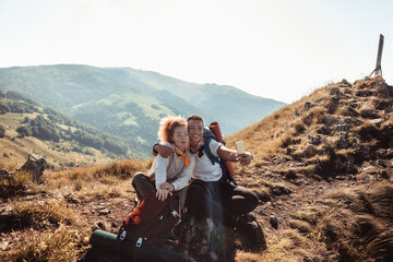 Young mixed lesbian couple taking a selfie while out hiking in the mountains and hills