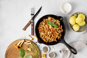 Cooked chanterelle mushrooms with onions and spices in a pan on the kitchen table grnished with...