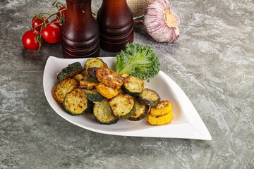 Roasted young zucchini in the plate