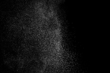 Abstract splashes of water on black background. Freeze motion of white particles. Rain, snow overlay texture.
