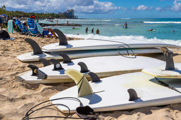 Waikiki beach in Honolulu, Hawaii, with surfboards and ocean view. Defocused background of unrecognizable people.