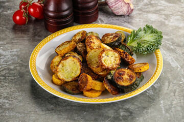 Roasted young zucchini in the plate