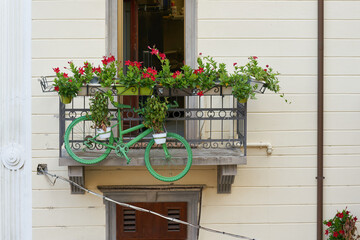 grünes Fahrrad mit Pflanzen als Dekoration auf einem Balkon in der Altstadt von Malcesine in Italien - 644586695
