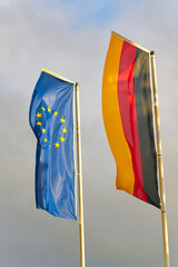 Fahnen der Europäischen Gemeinschaft und der Bundesrepublik Deutschland wehen gemeinsam im Wind 