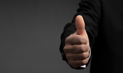 businessman giving thumbs up on black background with people stock photo