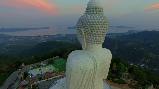 .aerial view Phuket big Buddha in beautiful sunset..the sun shines through the clouds impact on ocean surface.The beauty of the statue fits perfectly with the charming nature..cloud scape background.