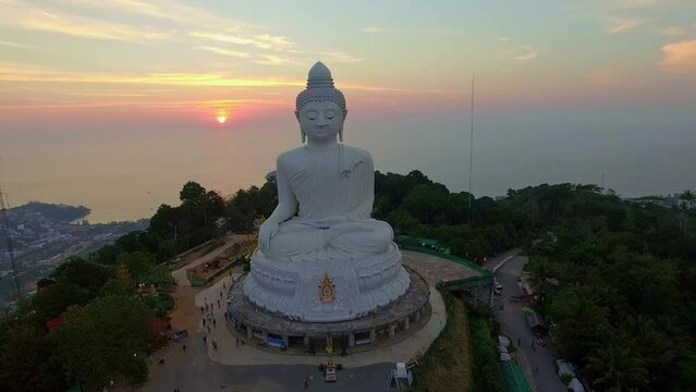 .aerial view Phuket big Buddha in beautiful sunset..the sun shines through the clouds impact on ocean surface.The beauty of the statue fits perfectly with the charming nature..cloud scape background.