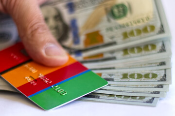 Hand holding Debit card and US 100 dollar banknotes, macro close up