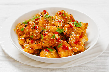 crispy orange cauliflower florets in white bowl
