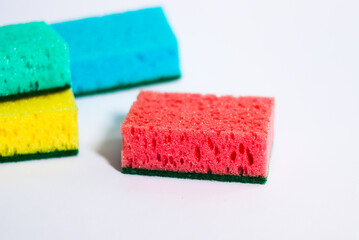 Colored sponges for dishes on a white background.