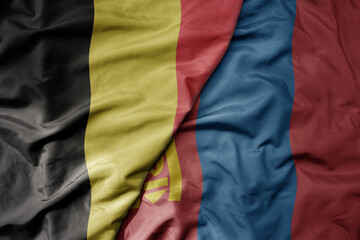 big waving national colorful flag of belgium and national flag of mongolia .