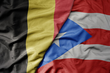 big waving national colorful flag of belgium and national flag of puerto rico .