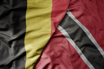 big waving national colorful flag of belgium and national flag of trinidad and tobago .