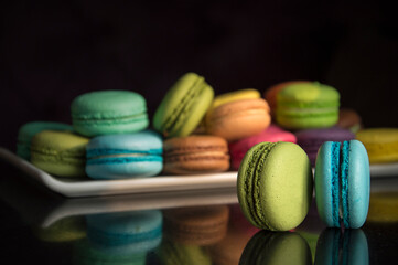 Multicolored almond cakes on a dark background