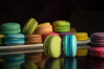 Multicolored almond cakes on a dark background