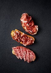 Italian Parma Ham, Coppa and Salami on bread toasts. Top view - 644612628