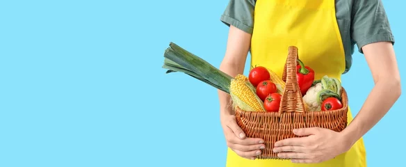 Foto op Aluminium Female farmer with wicker basket full of different vegetables on light blue background with space for text © Pixel-Shot