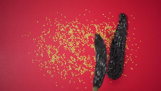 Placing dried mexican chili one by one on red surface with seeds
