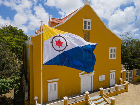 Bonaire, Kralendijk - September 06-2023: Bonaire Flag waving in front of the Lieutenant Governor office during Dia di Boneiru. - Powered by Adobe