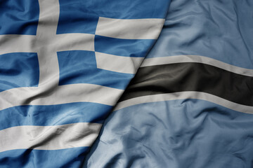 big waving national colorful flag of greece and national flag of botswana .
