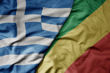 big waving national colorful flag of greece and national flag of republic of the congo .