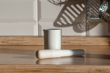 White porcelain mortar and pestle on the kitchen countertop on a sunny day