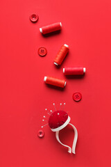 Composition with sewing supplies on red background