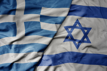 big waving national colorful flag of greece and national flag of israel .