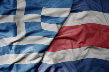 big waving national colorful flag of greece and national flag of costa rica .