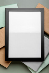 Blank picture frame with books on green background