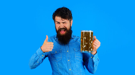 Beer degustation. Bearded man drinking beer from mug at bar or pub. Handsome man with pint of lager beer showing OK sign, thumb up. Winking man tasting glass fresh brewed beer. Oktoberfest festival.