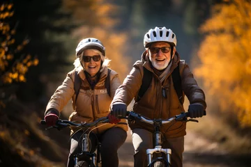 Foto op Plexiglas Happy mature couple riding bikes in helmets, bicycles in park. Cheerful active senior couple with bicycle in public park together having fun lifestyle. Safe and perfect activities for elderly people © Valeriia