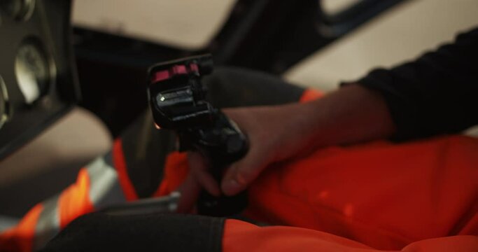 Close up shot of the cyclic, main control stick in helicopter. Male hand moving with lever between legs. Pilot performing preflight procedure in cockpit. Airport and aviation concept