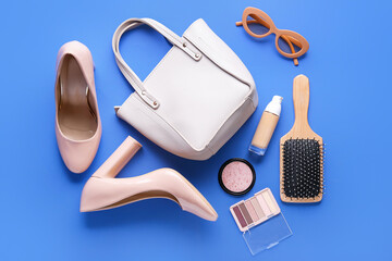 Composition with stylish high heeled shoes, accessories and cosmetics on blue background